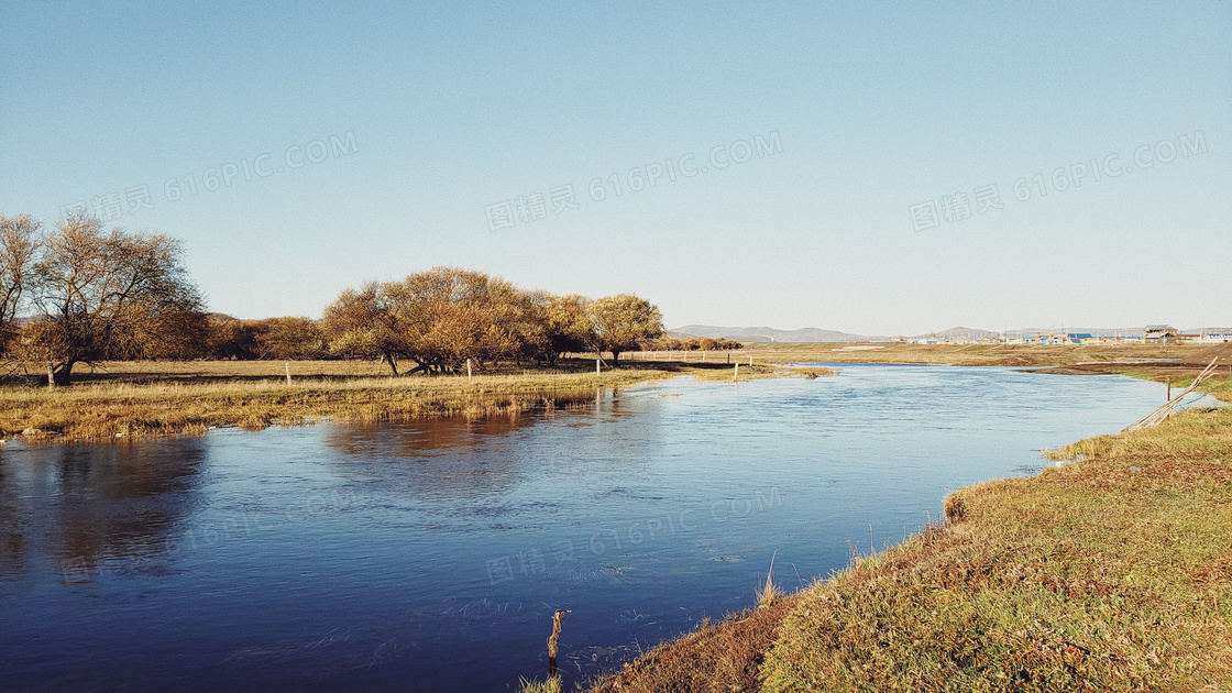 秋季蓝天下的河流和树木摄影图片