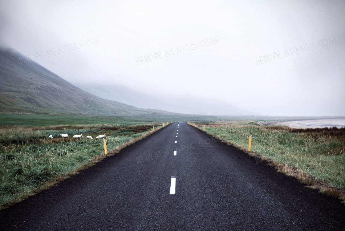 草地公路与浓雾之中的大山高清图片