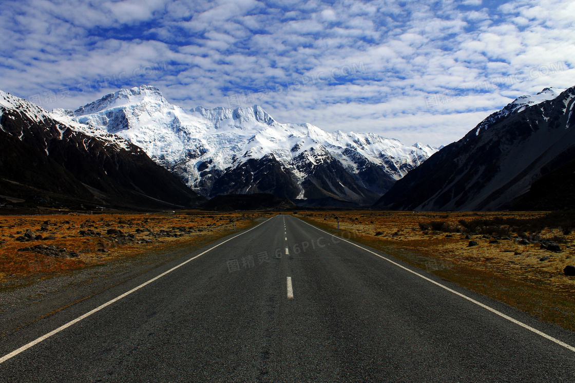 多云天空下的雪山道路摄影高清图片