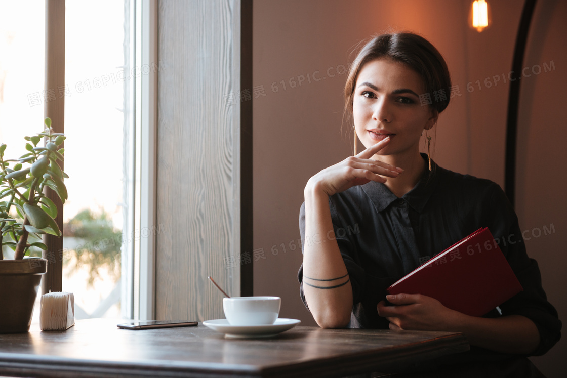 桌前抱着书的美女人物摄影高清图片