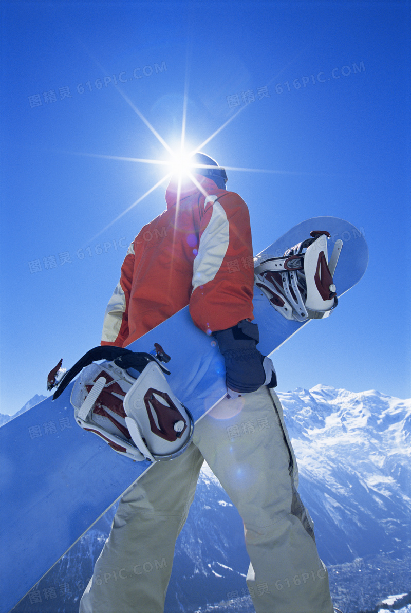 拿着滑雪板的人物逆光摄影高清图片