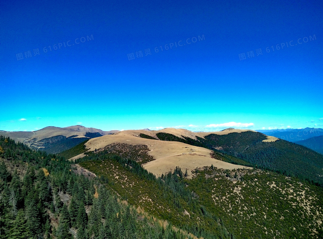 蓝天下的山峰和树林摄影图片
