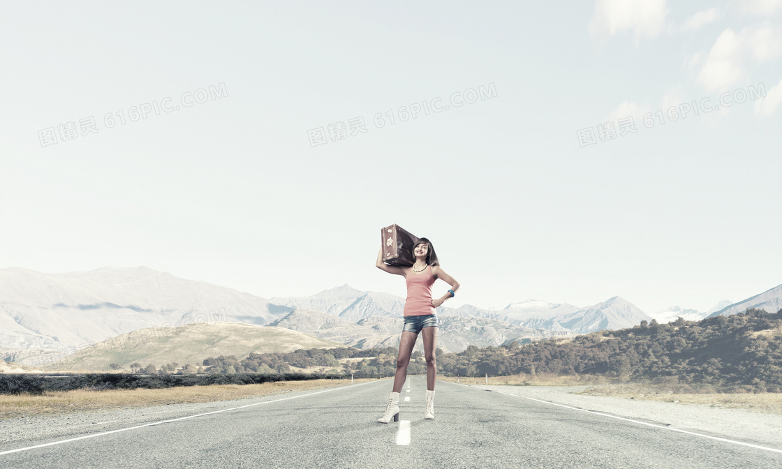 在路中间扛着旅行箱的美女高清图片