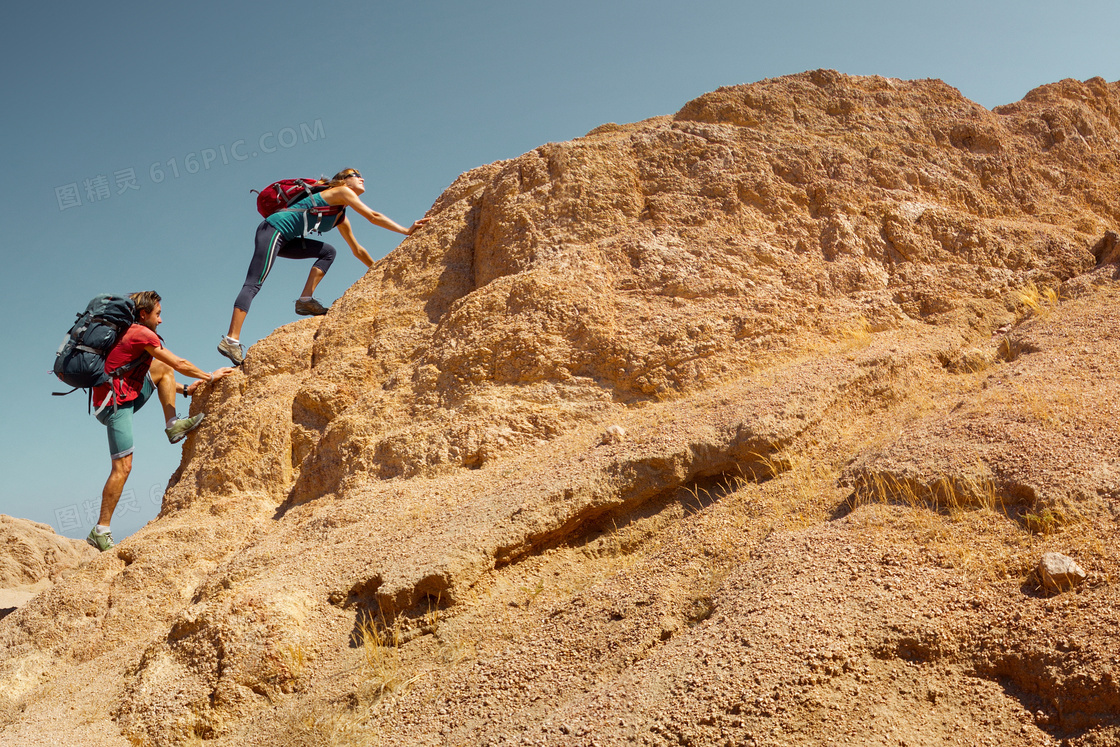 背着背包徒手爬山的人摄影高清图片