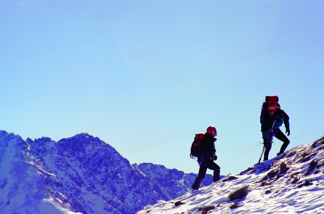 攀登雪山高峰的两个人摄影高清图片