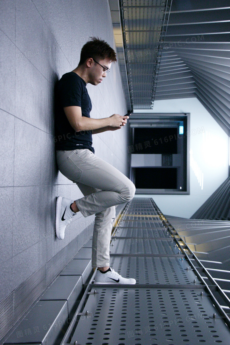 靠在墙上刷手机的帅哥图片