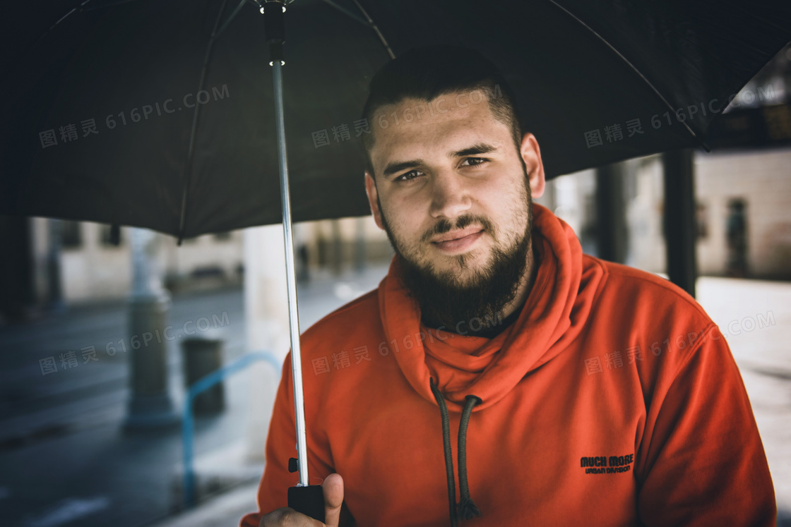 男人雨中撑伞图片