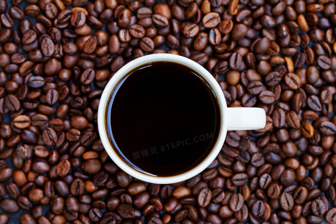 摆放在咖啡豆上的一杯咖啡高清图片