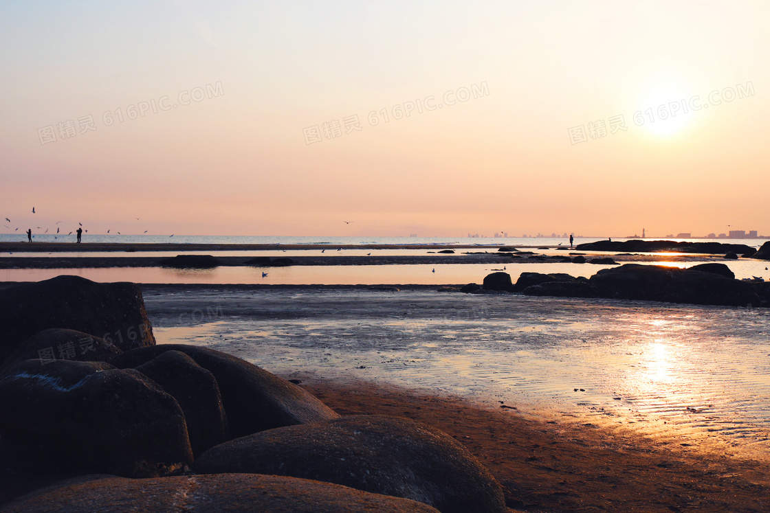 夕阳下的海滩和原石高清摄影图片