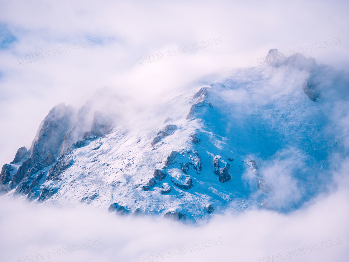 云雾缭绕的雪山景观摄影图片
