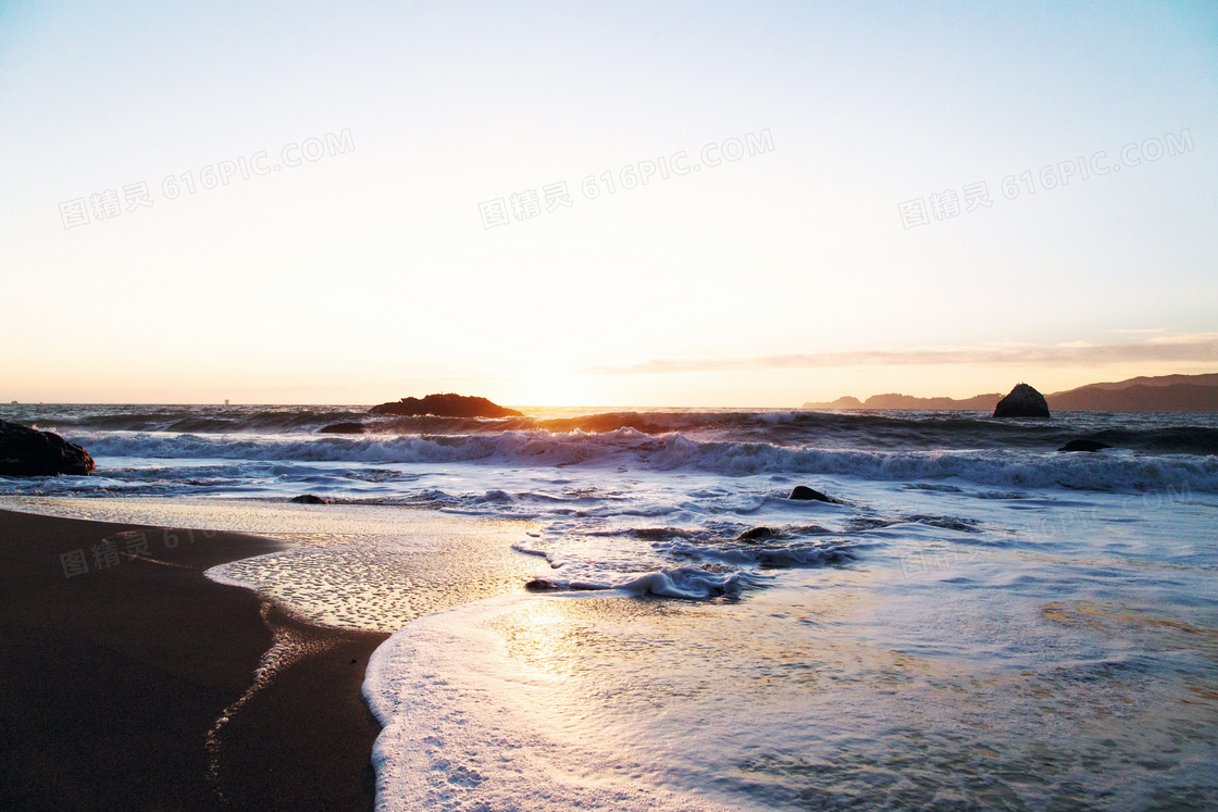 夕阳下的海边海滩和海浪摄影图片