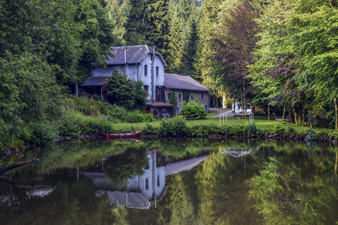 树林中的房屋和池塘摄影图片