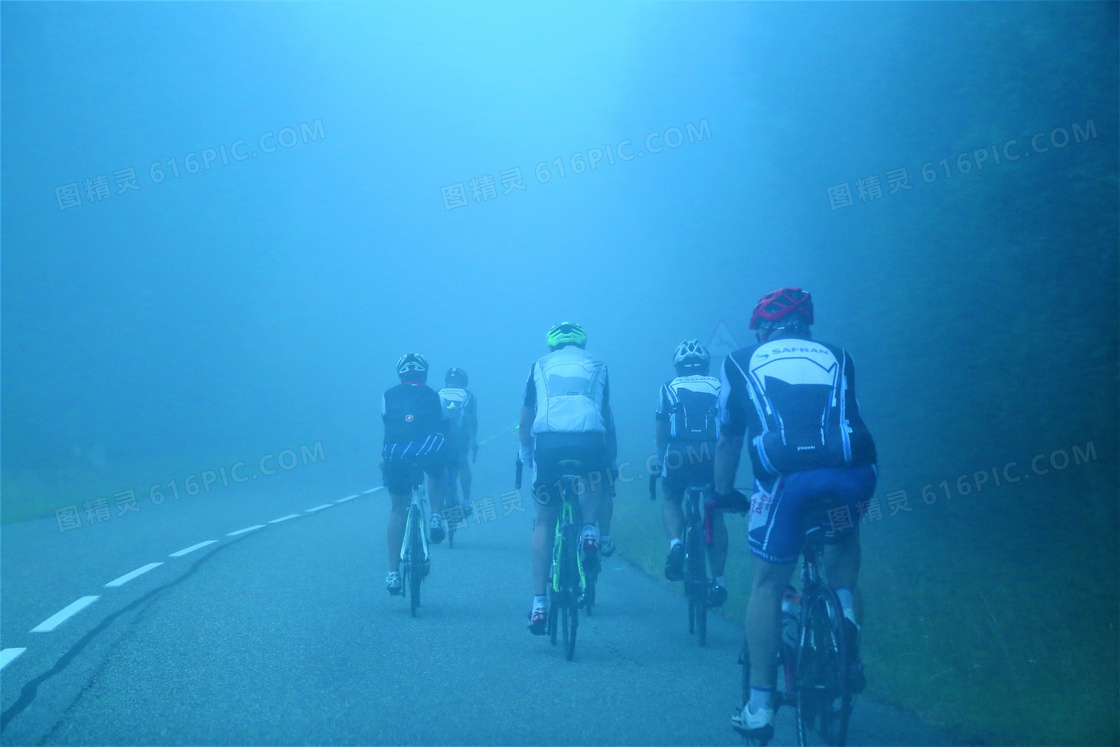 大雾公路上骑行的人群摄影高清图片
