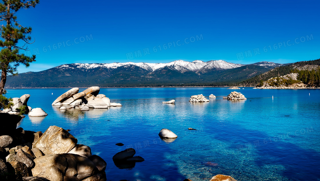 蓝天下湖泊中的岩石景观摄影图片