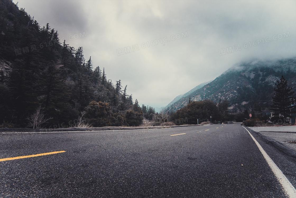 柏油路与雾气笼罩下的大山高清图片
