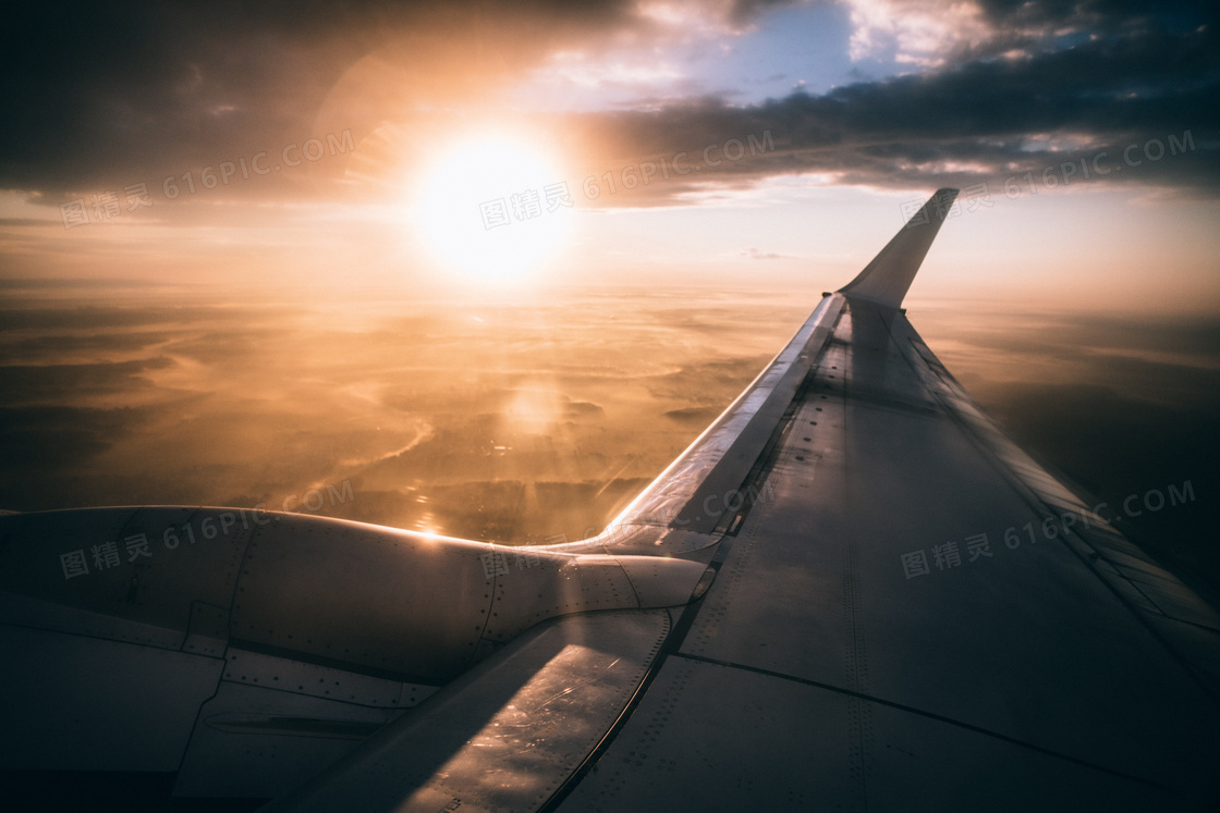 乌云阳光下的飞机机翼摄影高清图片