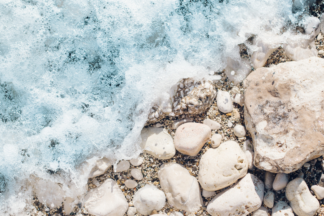 拍打着海边沙子石头的海水高清图片