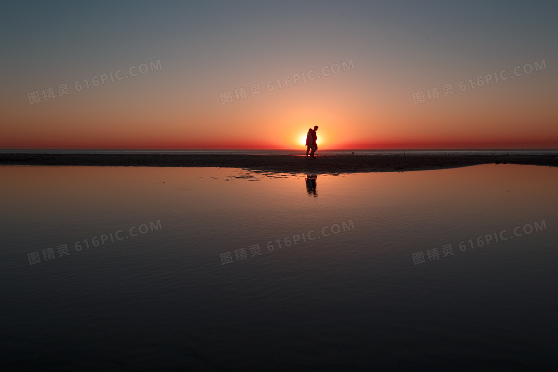 夕阳余晖下的情侣人物剪影高清图片