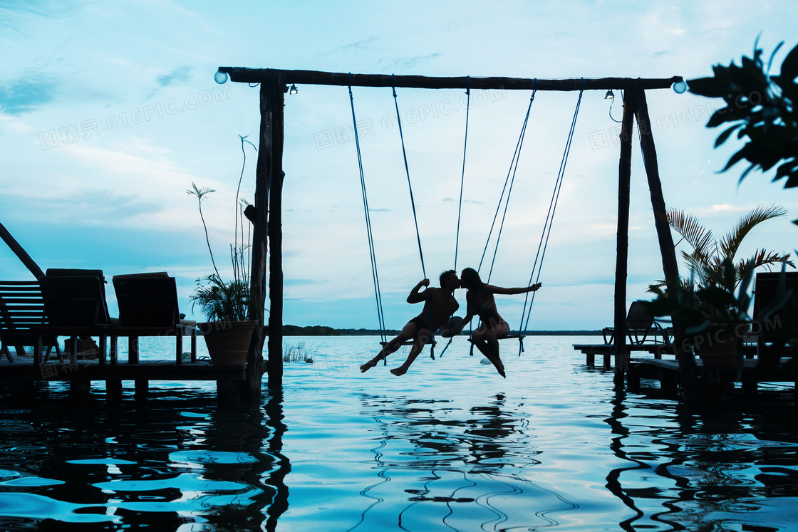 在水面上荡秋千的情侣摄影高清图片