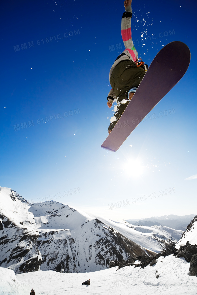 茫茫雪山与空中的滑雪人物高清图片