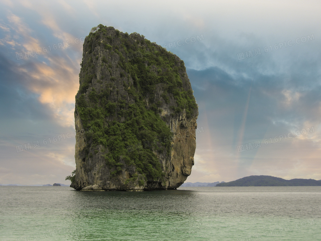 大海中长满植被的巨石摄影高清图片
