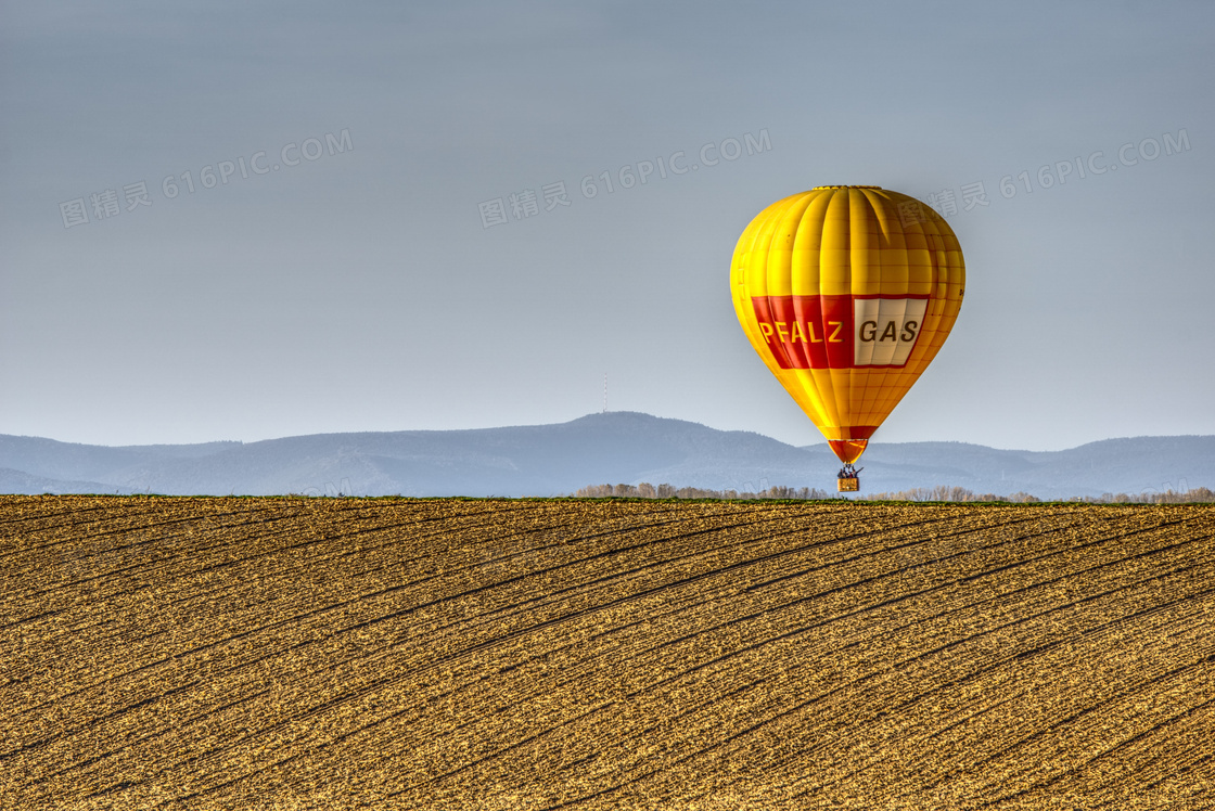 山峦与在农田上空的热气球高清图片