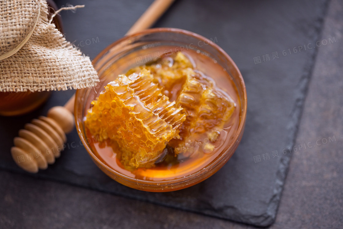 搅拌棒与在玻璃碗里的蜂蜜高清图片