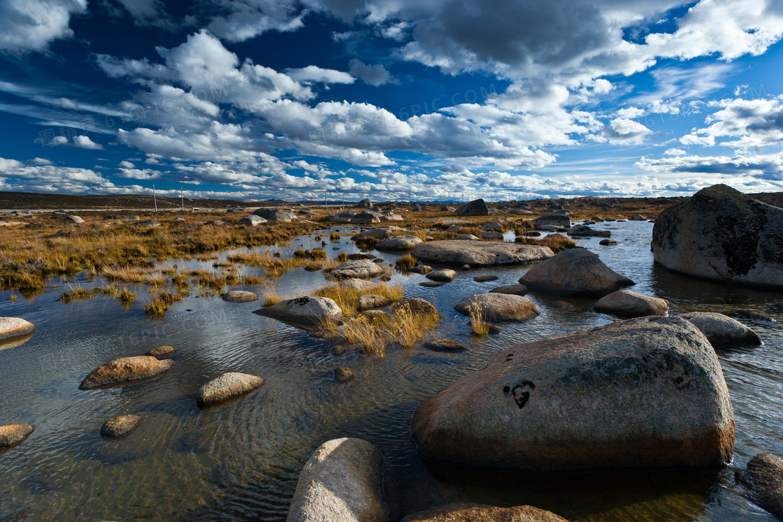 蓝天下的河边岩石摄影图片
