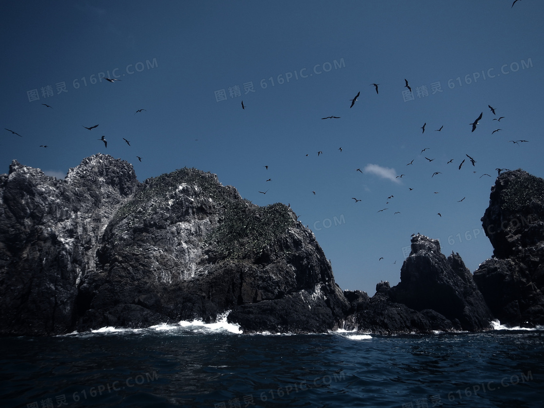 蓝天山石与飞翔的海鸟摄影高清图片