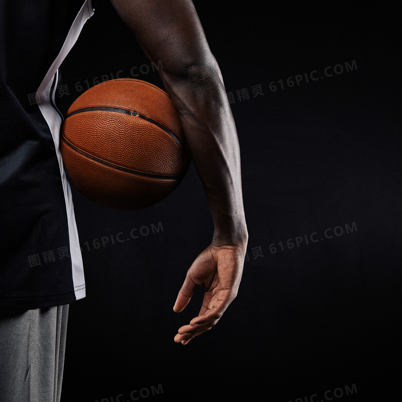 把篮球夹在腰间的男子摄影高清图片