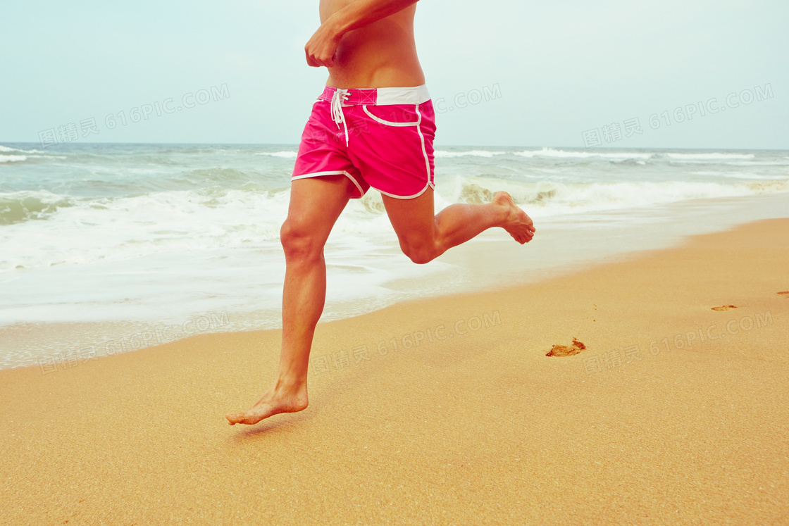 海边沙滩上奔跑的男子摄影高清图片