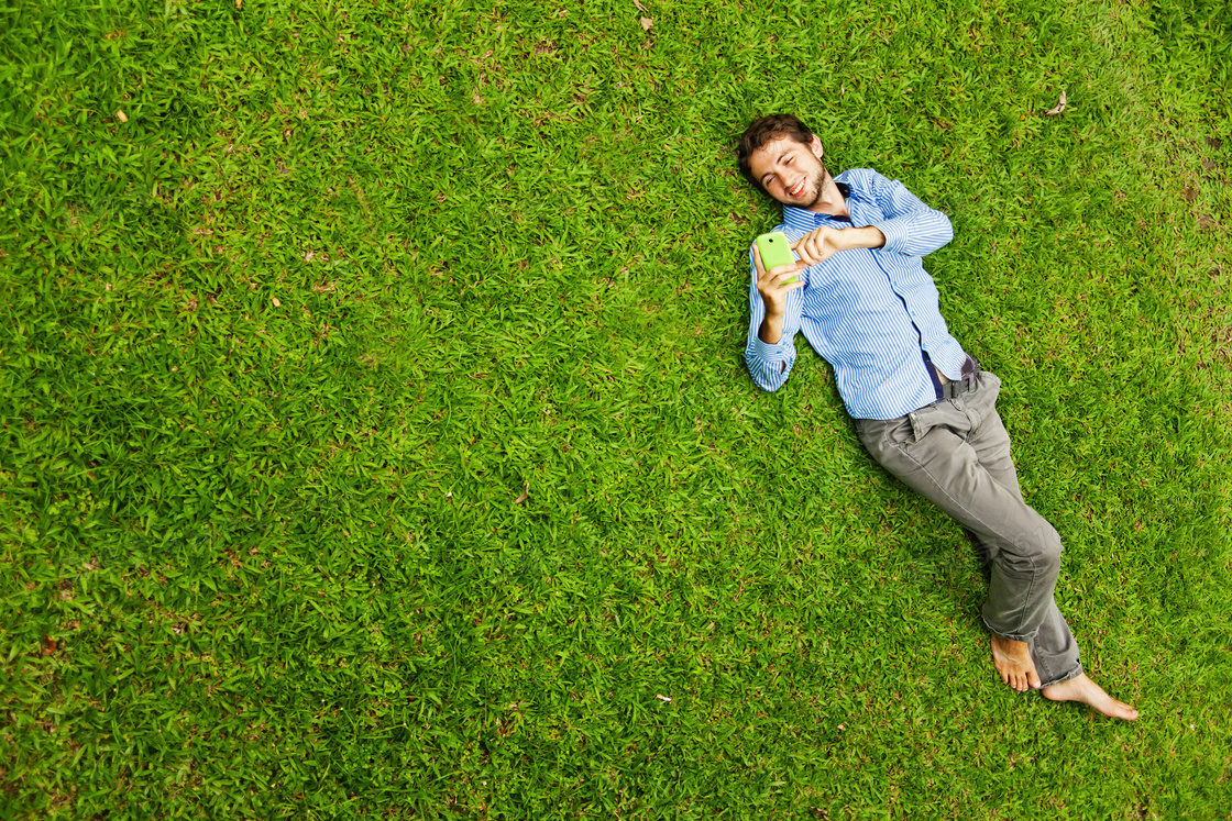 赤脚躺在草地上的男子摄影高清图片