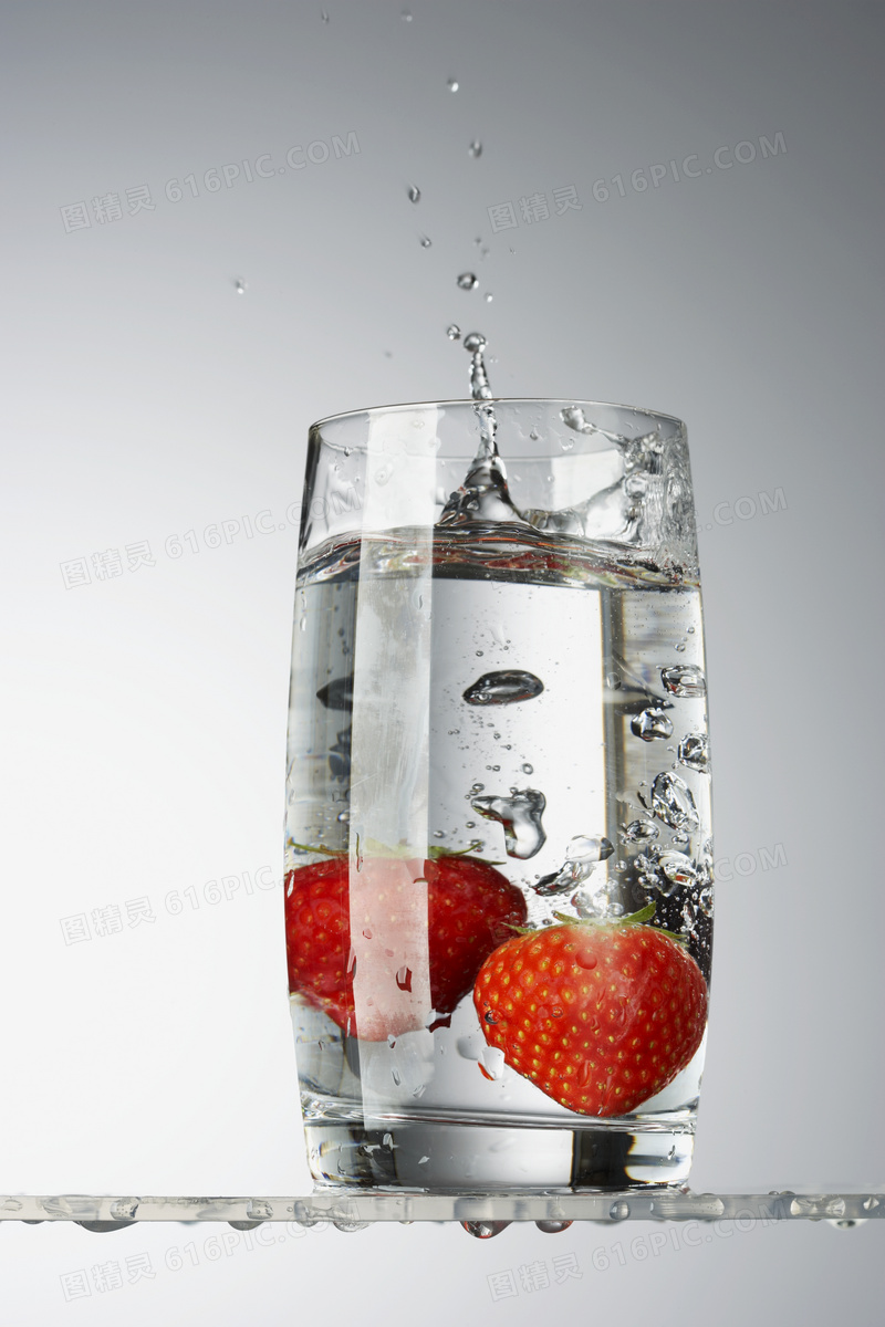 放在水杯里的两个草莓摄影高清图片