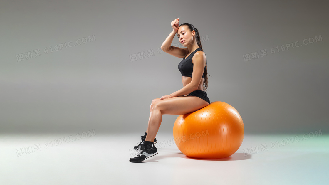 橙色健身球上的马尾发美女摄影图片