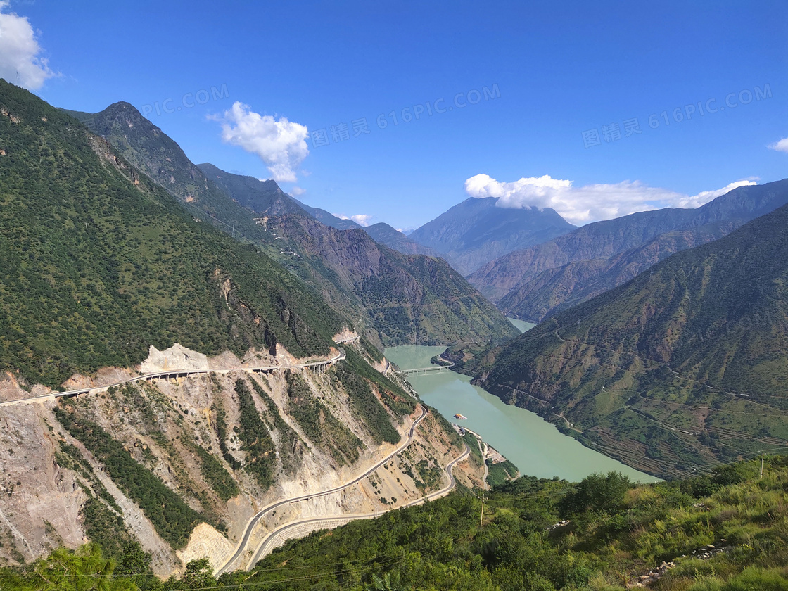 大山中的盘山公路和湖泊摄影图片