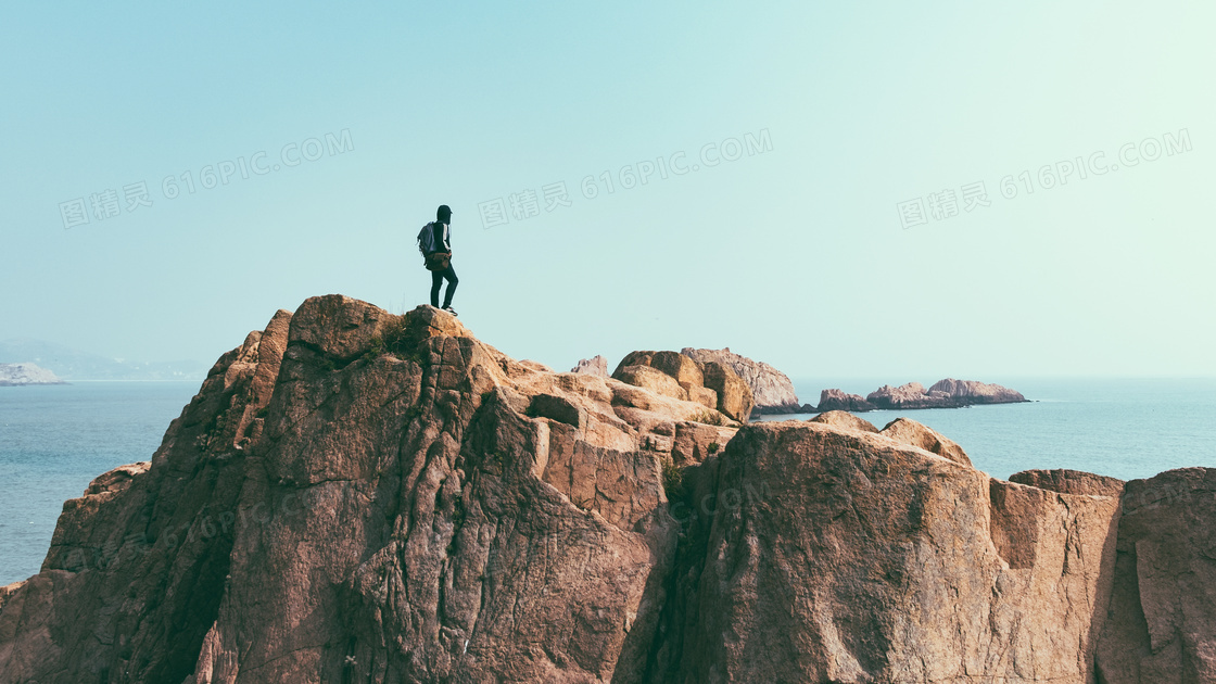站在海边悬崖上的男人摄影图片